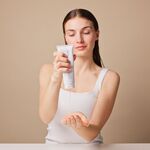 Frau gibt eine Handcreme für trockene Haut aus der Tube in die Hand – Anwendung des SENSITIVE Hand & Nail Balm.