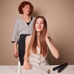 Anwendung der GLYNT MALIBU Anti Frizz Creme im Salon: glattes, gepflegtes Haar während des Stylings.