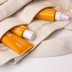 GLYNT SUN Pflegeprodukte in einer Stofftasche – Shampoo, Maske und Spray für sonnengestresstes Haar.