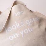 Beige GLYNT Stofftasche mit Aufdruck „looks good on you“, Nahaufnahme des Materials.