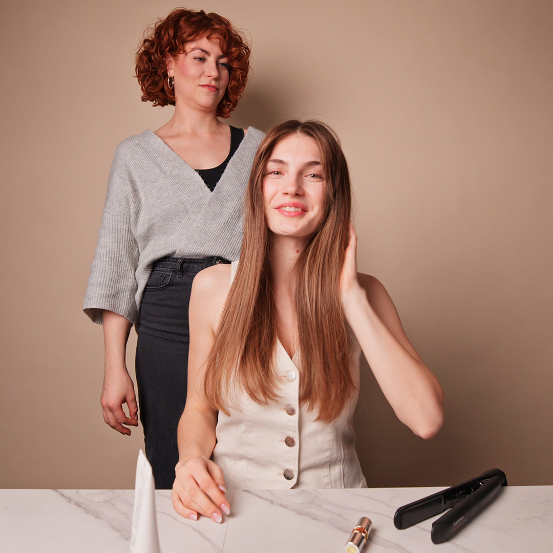 Anwendung der GLYNT MALIBU Anti Frizz Creme im Salon: glattes, gepflegtes Haar während des Stylings.