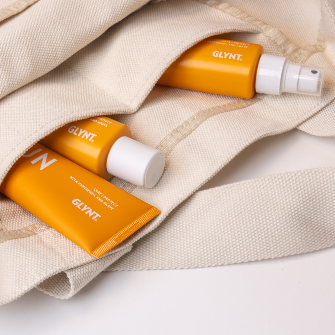 GLYNT SUN Pflegeprodukte in einer Stofftasche – Shampoo, Maske und Spray für sonnengestresstes Haar.